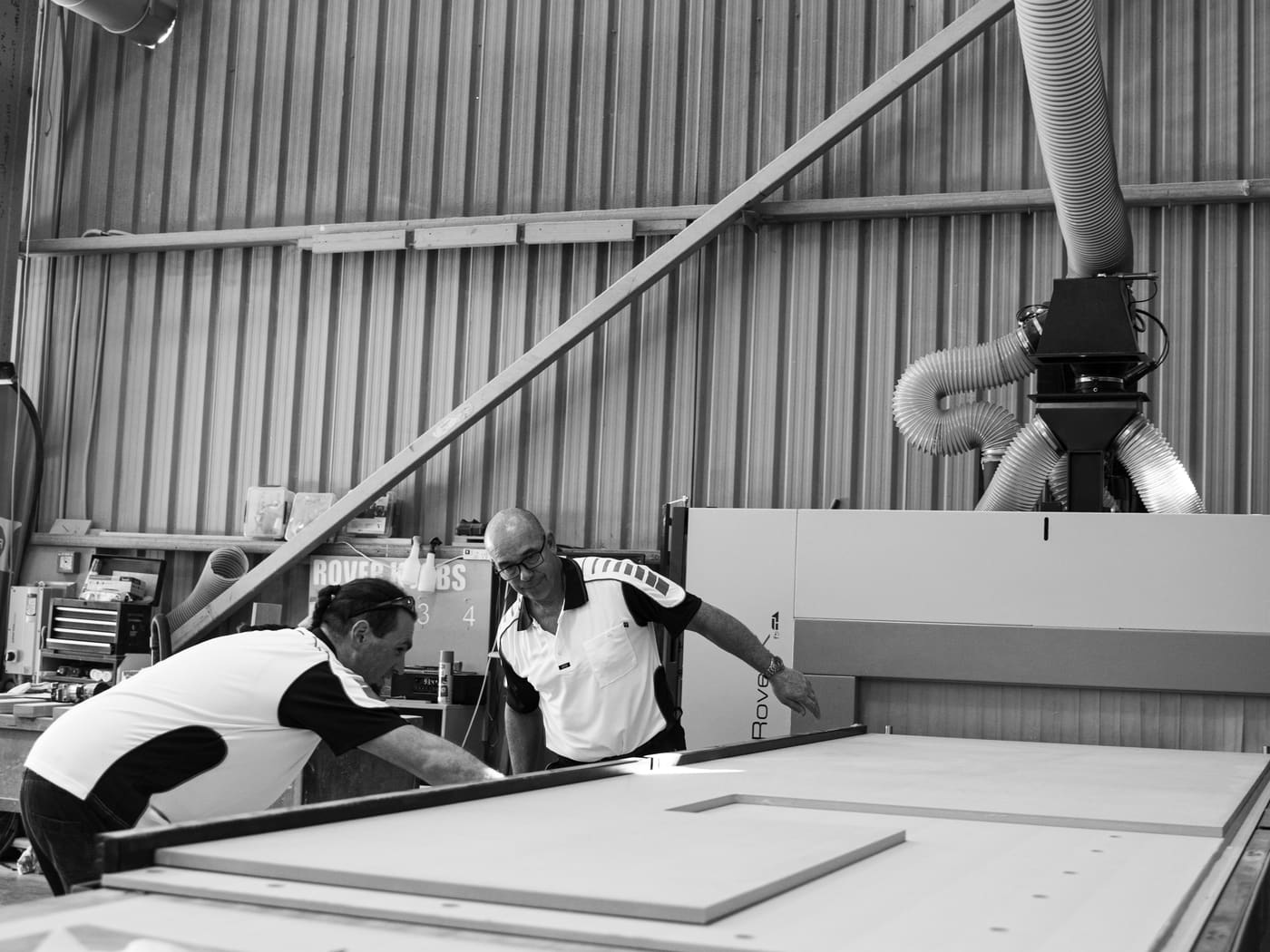 Two of the team setting a sheet on the CNC machine