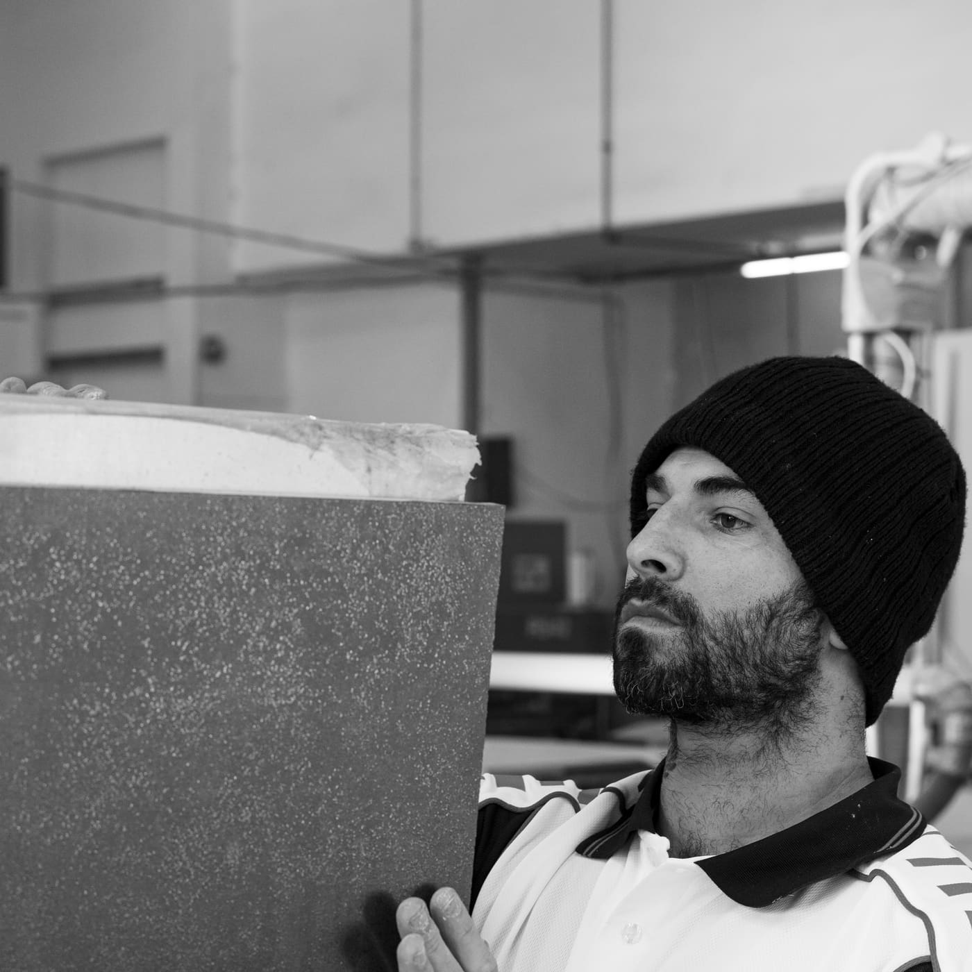 Fabricator carrying a stone slab in the workshop